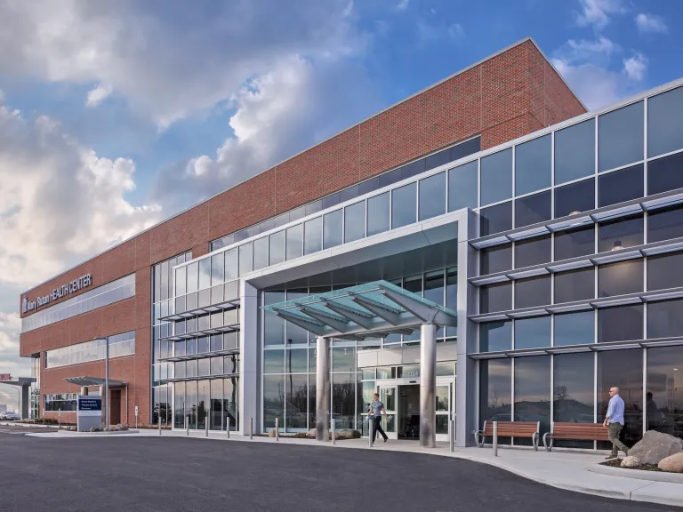 Exterior of Mary Rutan Hospital health center entrance with a blue cloudy sky