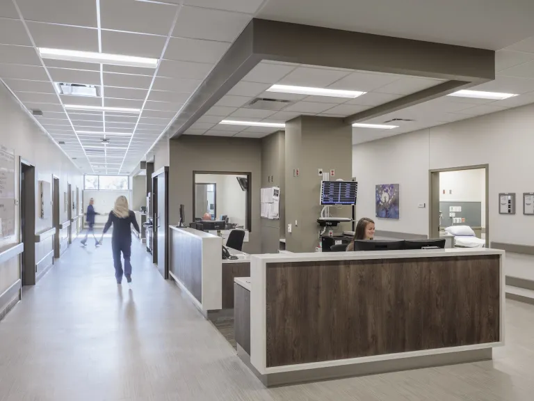 Nurse's station with dark wood paneling in between two hallways
