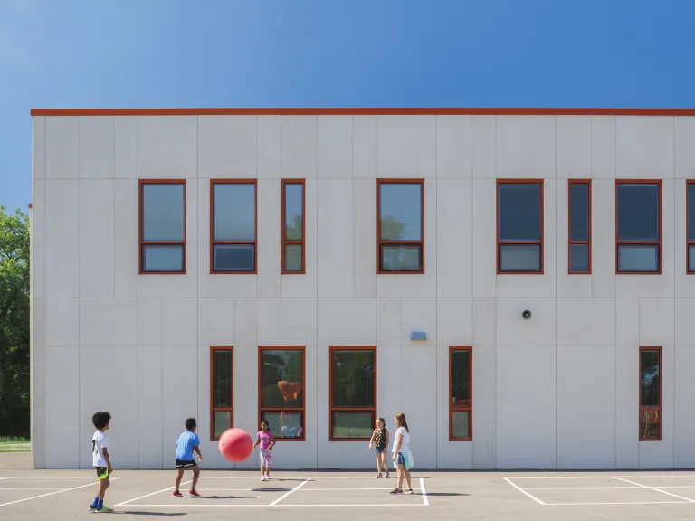 Students playing outside in a courtyard outside of a school.