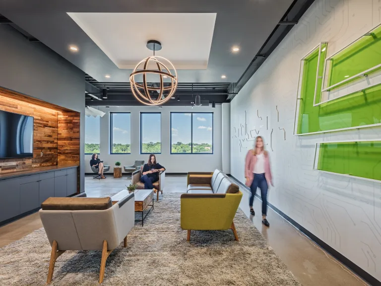 Interior of a lobby or lounge space with modern couches and a wall featuring a motherboard tech design