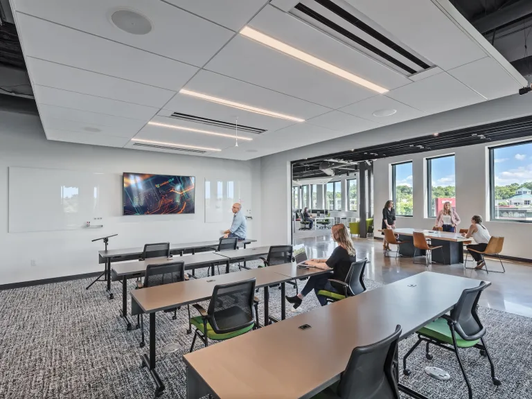 Open conference space with classroom style set desks facing a television