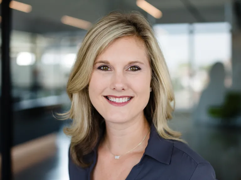 Lindsay Andrews smiling, wearing a dark grey blouse