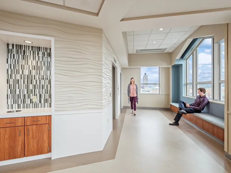 Elevator entrance of the 8th floor of the UPMC Mercy Hospital, featuring wavy textured tan walls and blue accents