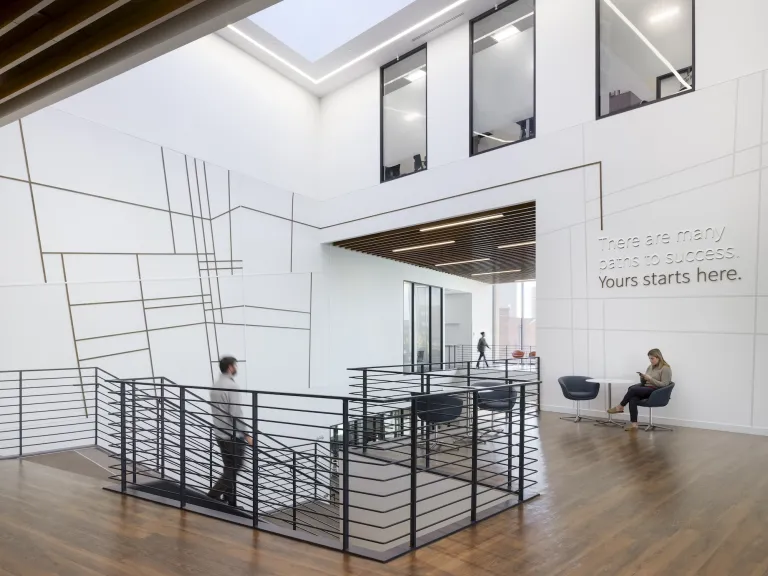 Interior of Mitchell Hall at the top floor stair case, featuring quiet spaces of tables and chairs