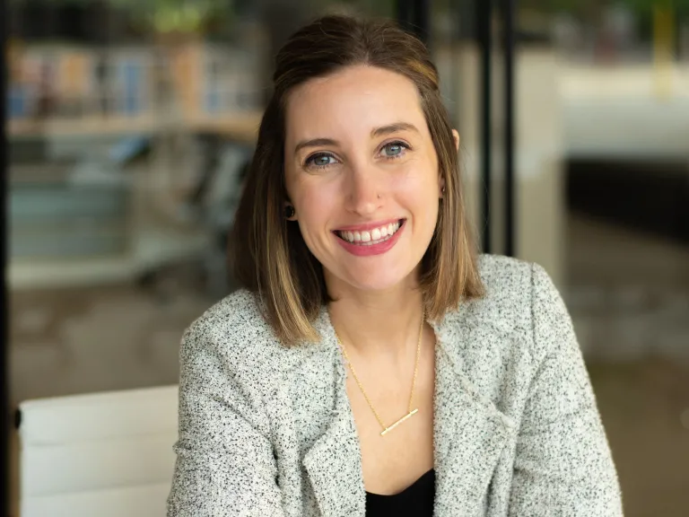 Nicole DeFazio smiling, wearing a gray blazer and black blouse