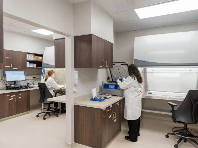 Interior of a hospital lab with two women testing blood samples