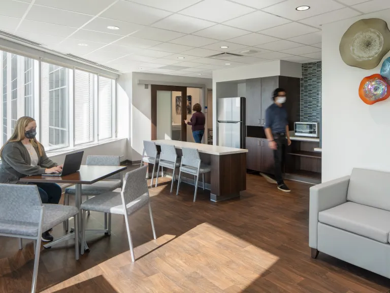 Family waiting room inside of a hospital, featuring a kitchenette and tables with chairs