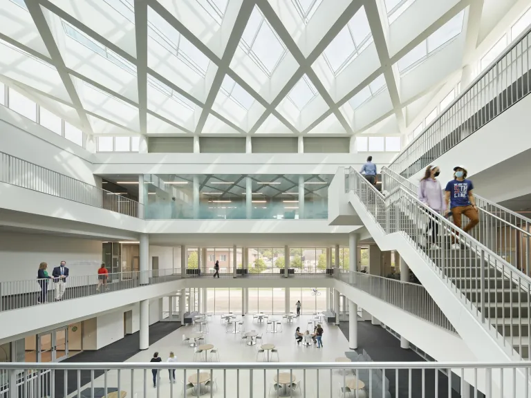 Interior of the Heritage College building from the second floor, overlooking atrium of students and large stair case on the right hand side