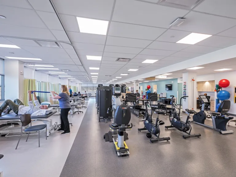 Interior of a physical therapy space, variety of benches and exercise equipment