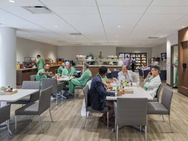 Group of doctors and nurses in scrubs and lab coats in a grab and go cafeteria