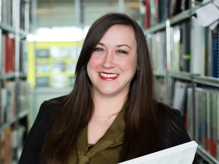 Riley Zollars smiling, wearing a black blazer and dark green blouse