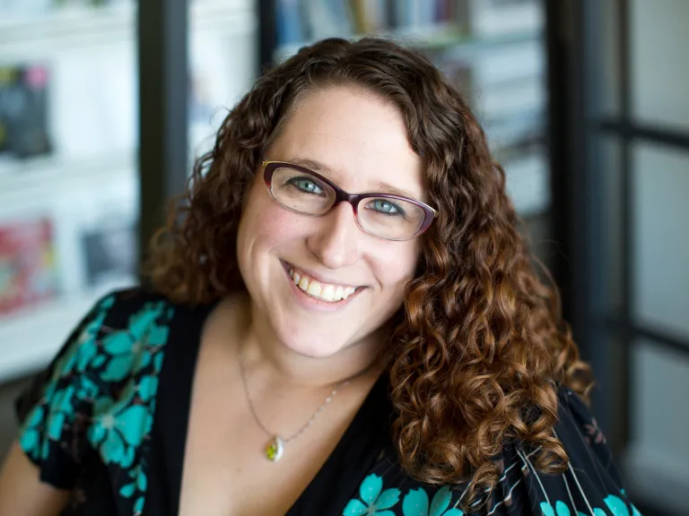 Sarah Eversman smiling, wearing a teal and black floral blouse