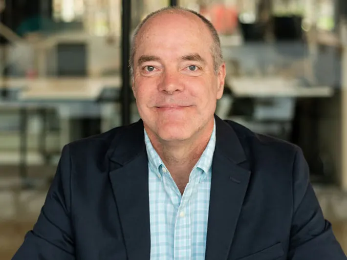 Tom Chidlow, smiling while wearing a navy blazer and blue shirt