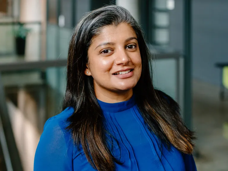 Veneetha Jose smiling, wearing a blue sweater