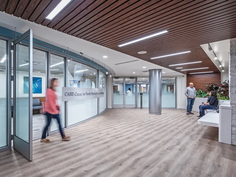 Interior view of a person walking through a door into a health facility.