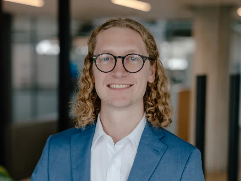 man with glasses and blue jacket