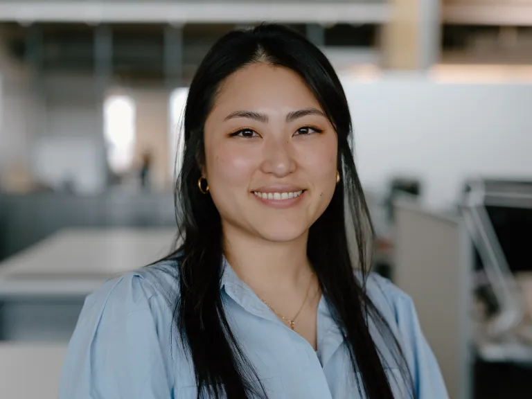 woman with straight dark hair wearing a light blue blouse