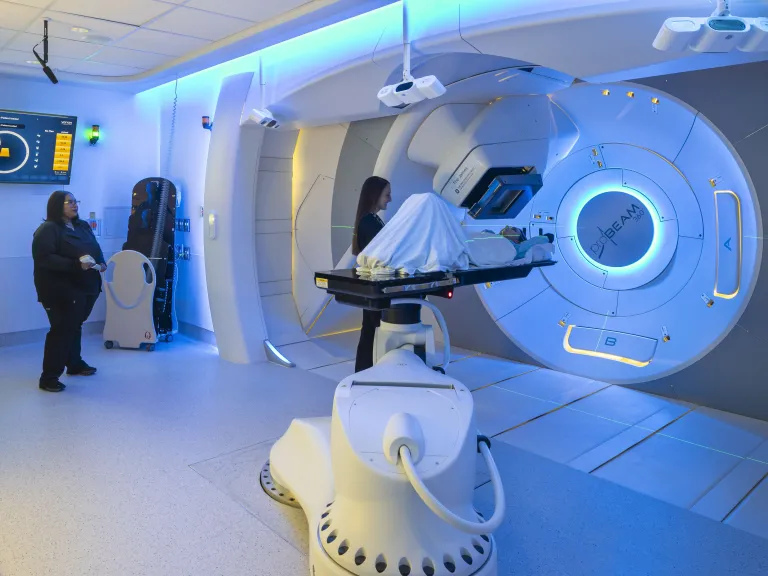 Nurses preparing patient for treatment with large medical device