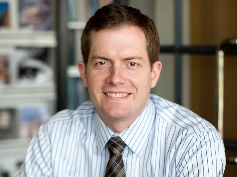 man in striped blue shirt and plaid tie