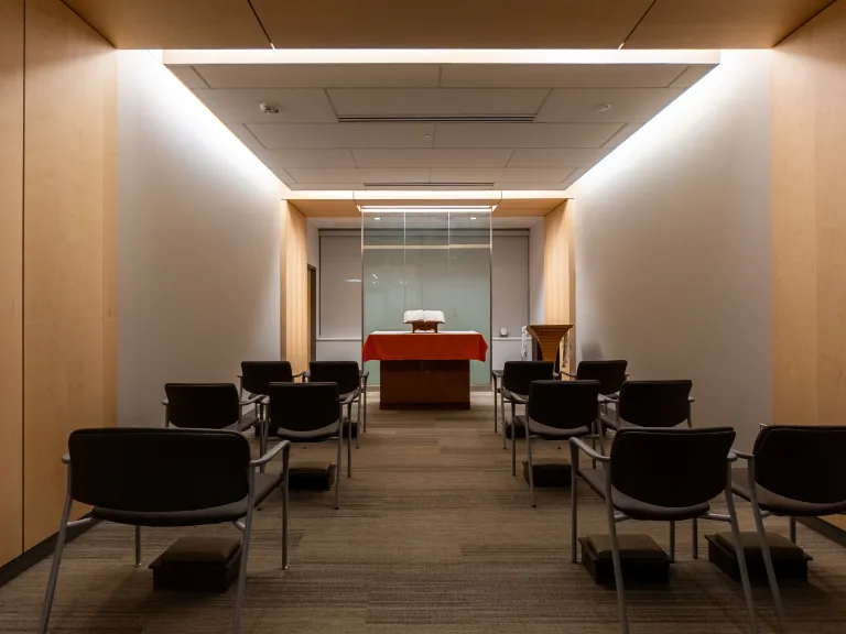 dimly-lit multi-faith room with modern wood paneling