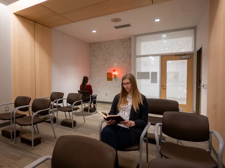 multi-faith room with modern wood paneling and tiled wall with tabernacle