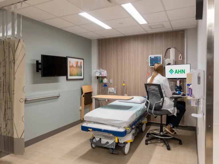 doctor sitting at desk in outpatient recovery bed room