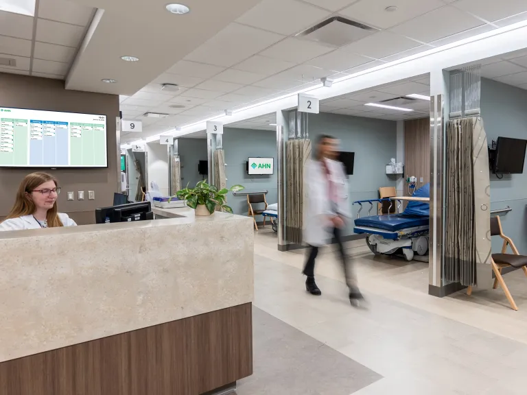 doctor walking past nurse station in outpatient recovery unit
